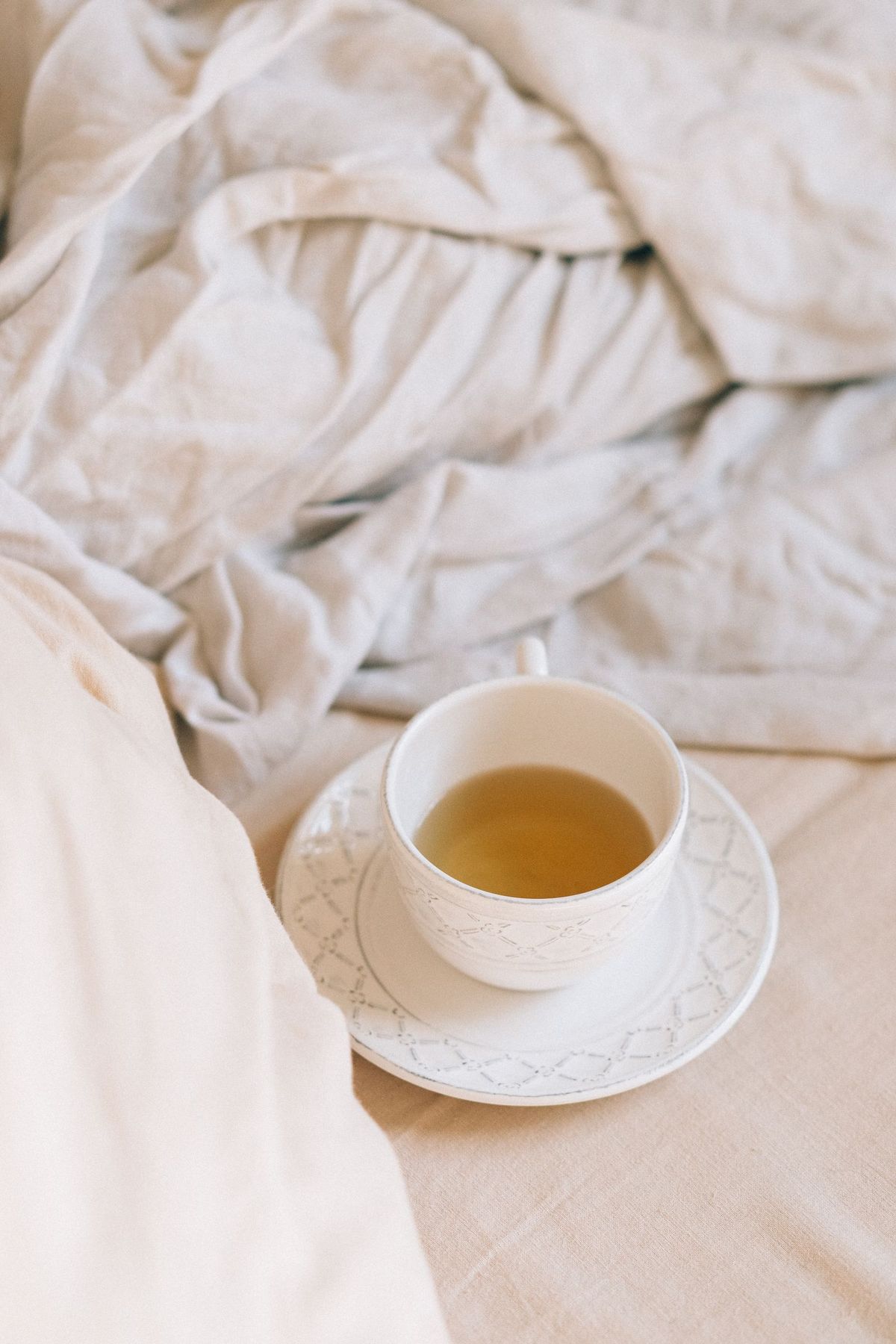 A cup of herbal tea on soft, neutral linen
